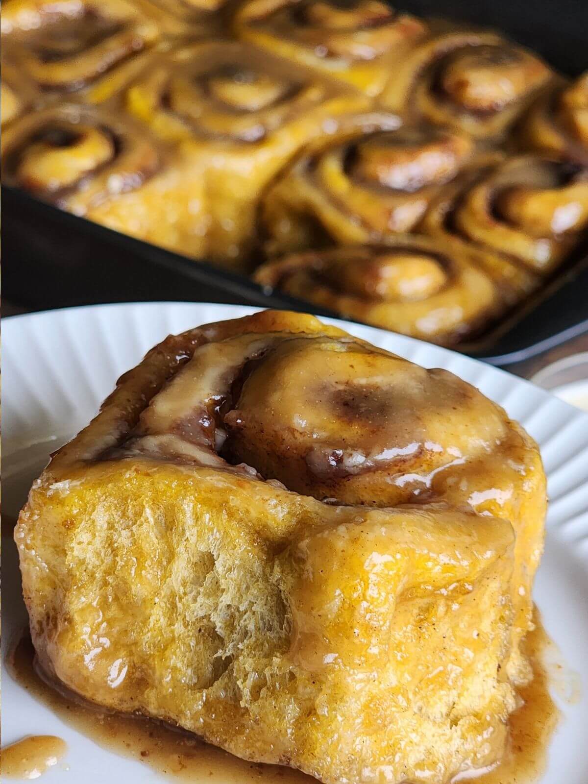 Sourdough pumpkin cinnamon roll served with caramel glaze.