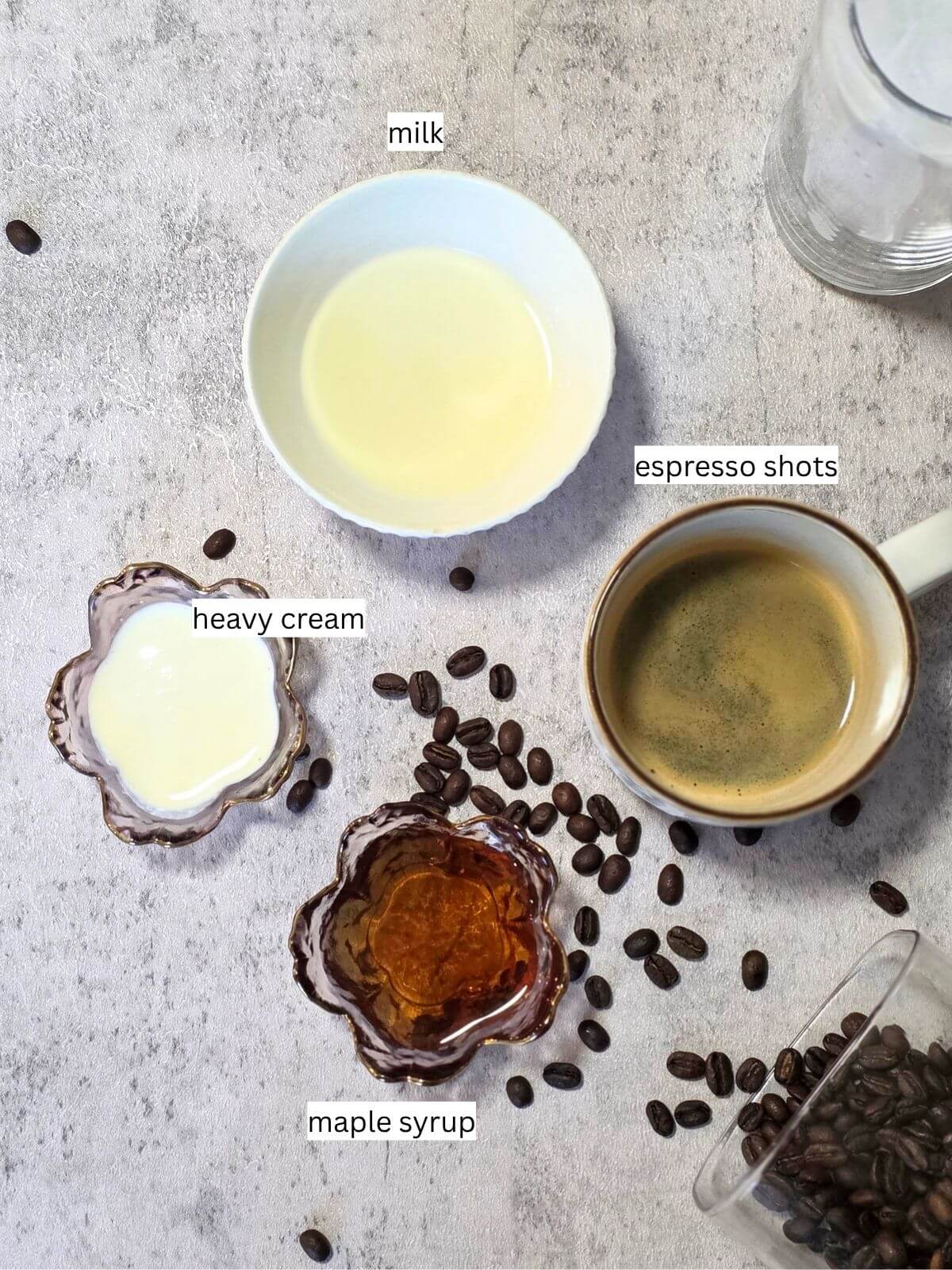 Ingredients for homemade maple iced coffee including milk, heavy cream, espresso and pure maple syrup.
