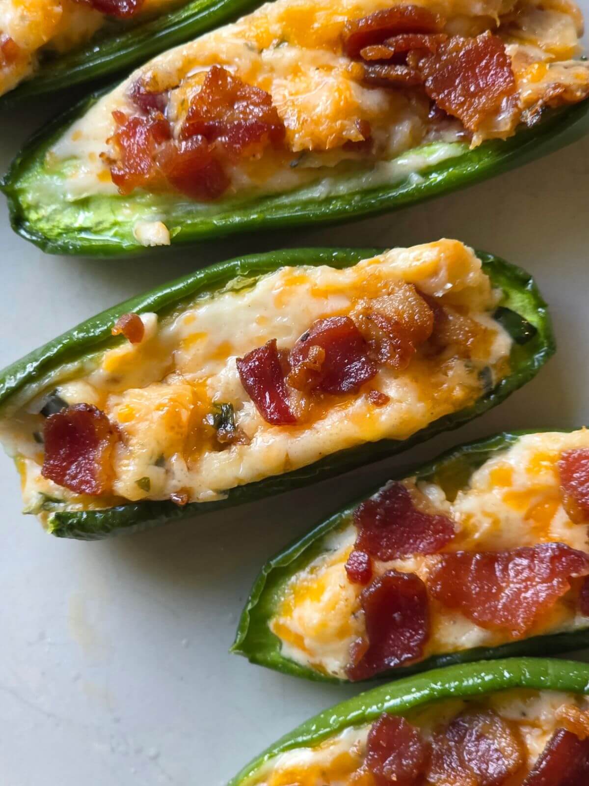 Baked jalapeño poppers filled with cream cheese, cheddar, chives, and bacon