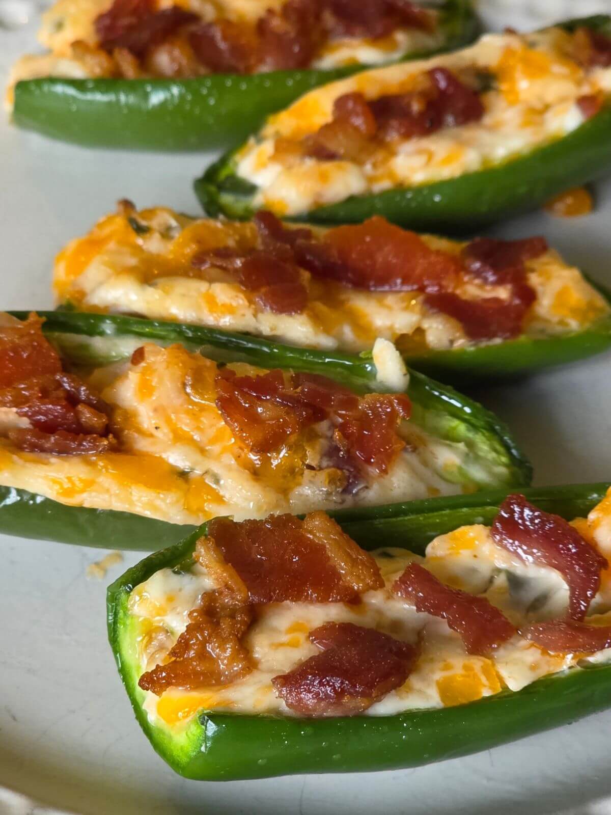 Baked jalapeño poppers filled with cream cheese, cheddar, chives, and bacon.