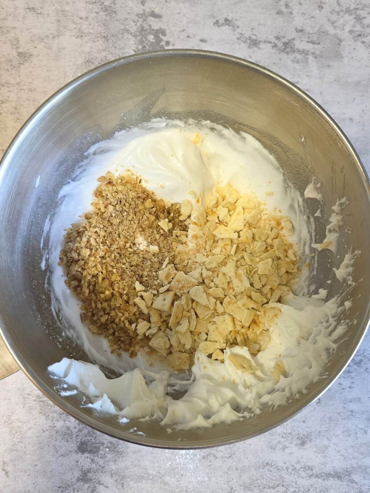 Crushed soda crackers and chopped walnuts added to whipped egg whites.
