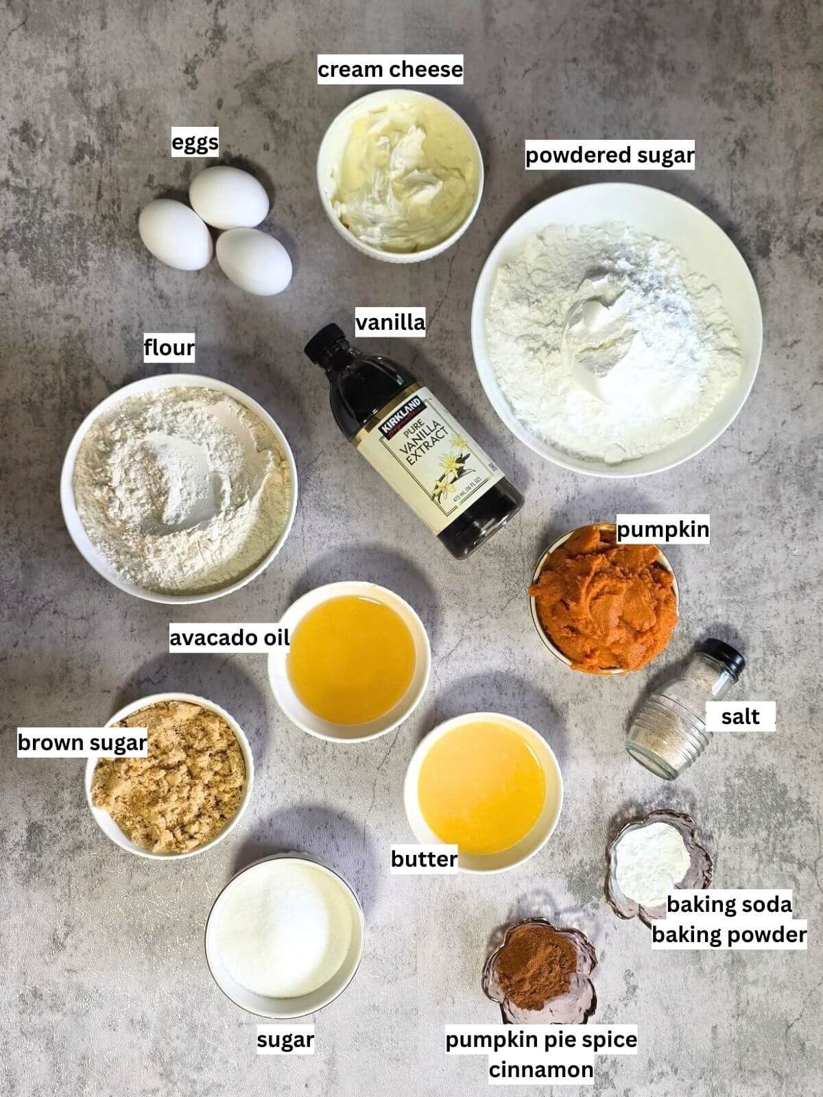 Ingredients for pumpkin spice Bundt cake and cream cheese frosting arranged on a countertop.