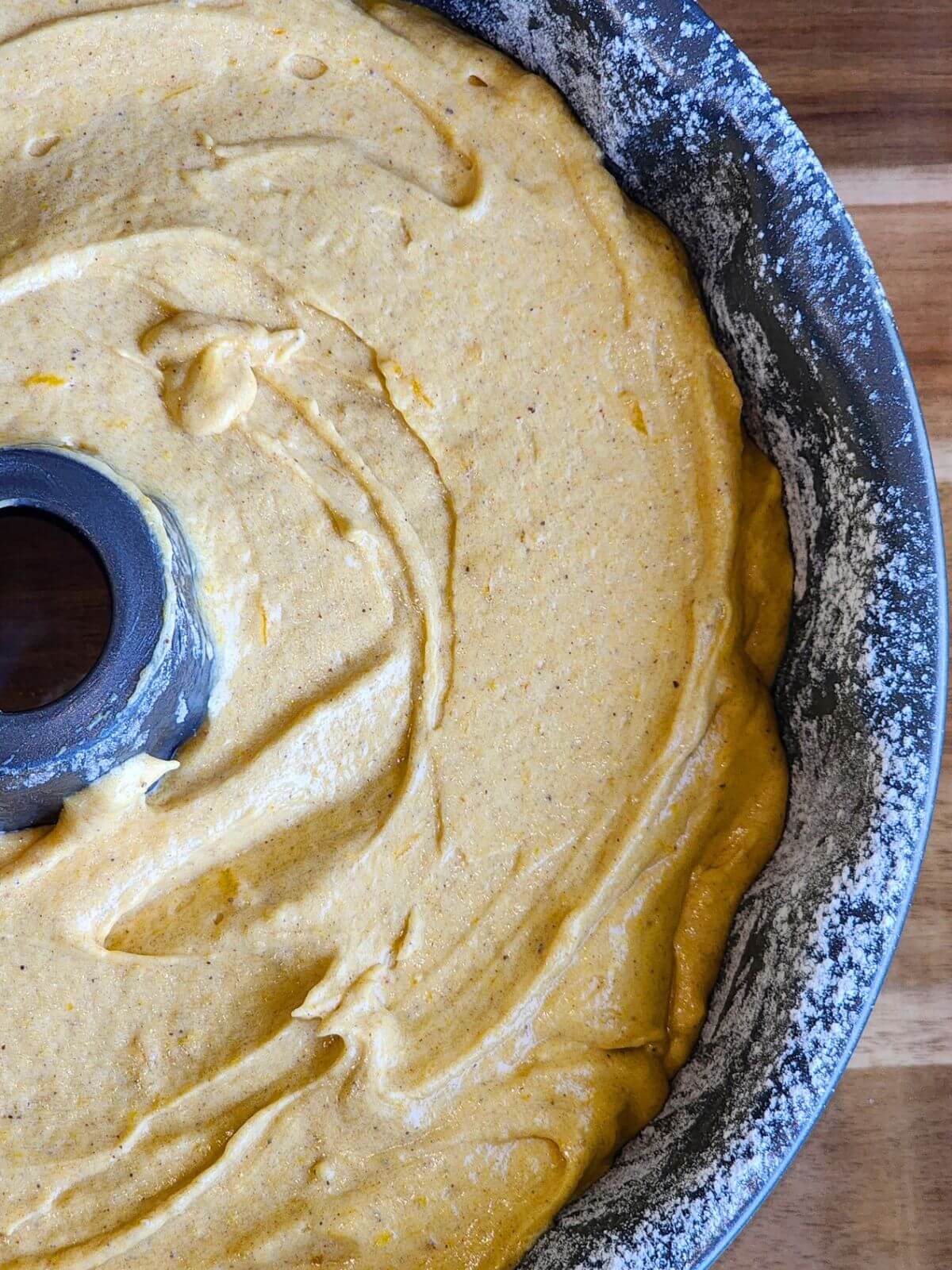 Pumpkin spice Bundt cake batter spread evenly in a prepared Bundt pan before baking.