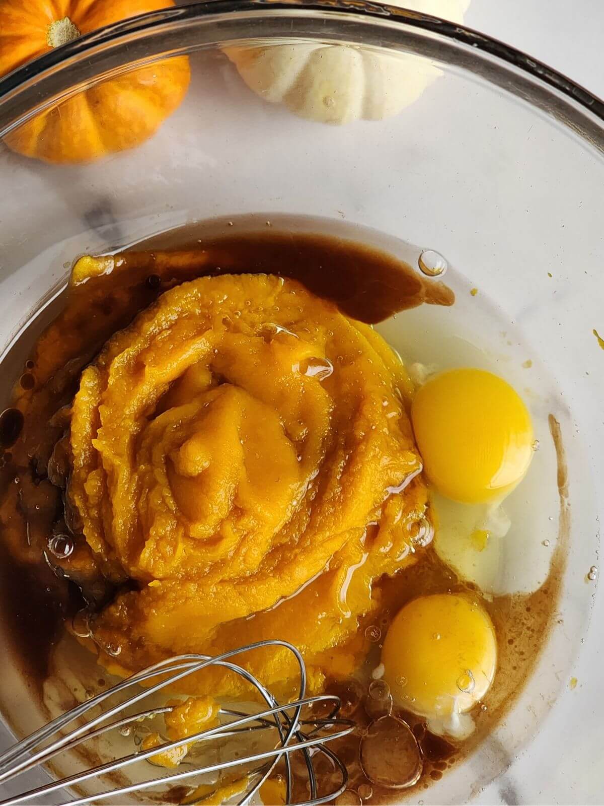 Pumpkin puree, eggs, vanilla, brown sugar, and melted coconut oil in a mixing bowl.
