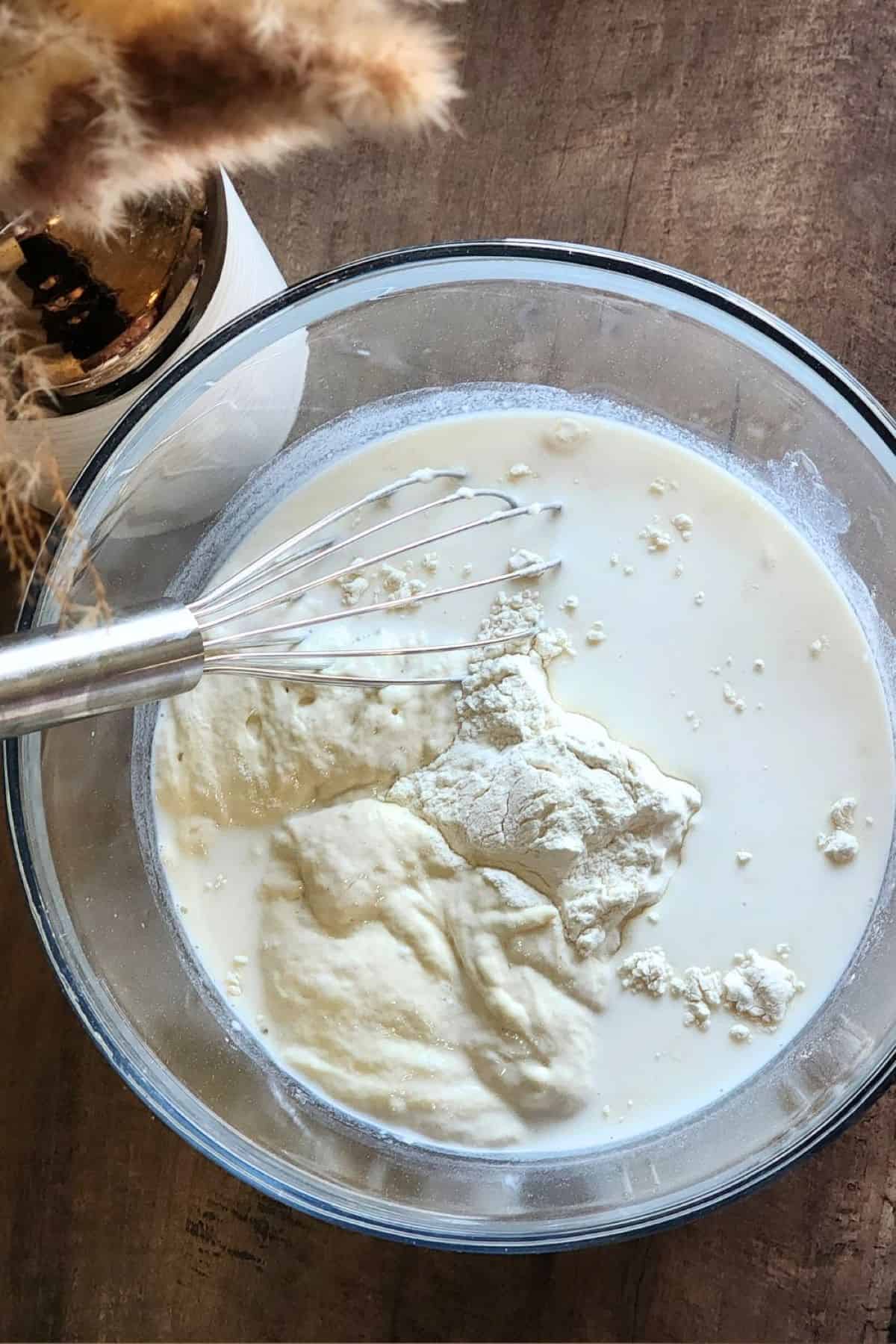 Sourdough pancake batter unmixed with whisk in bowl.