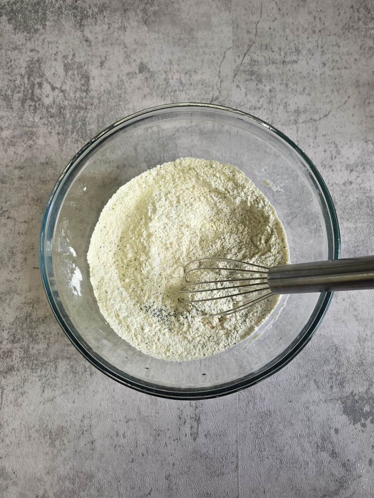 Dry ingredients for almond poppy seed scones in a mixing bowl.