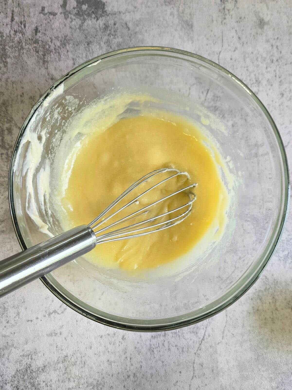 Melted butter, sugar, sourdough starter, egg, egg yolk, and vanilla whisked together in a glass mixing bowl.