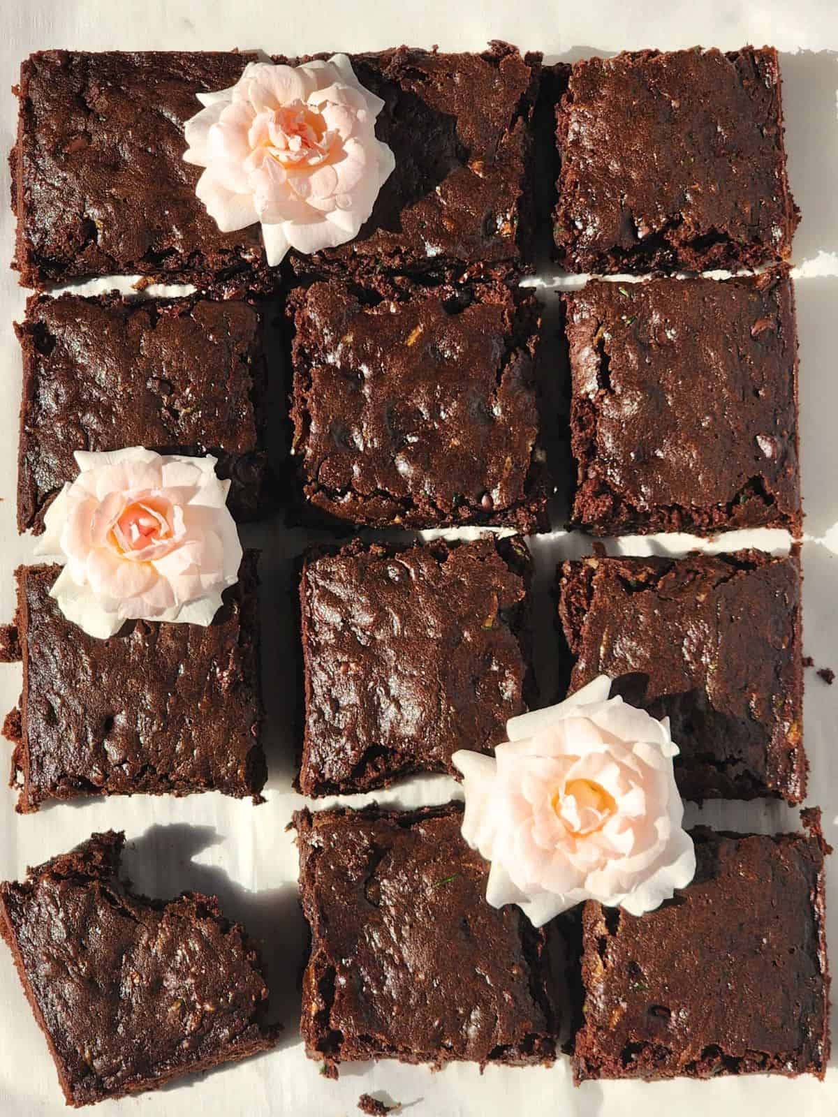Sourdough Chocolate Chip Zucchini Brownies cut into squares with roses for decoration.