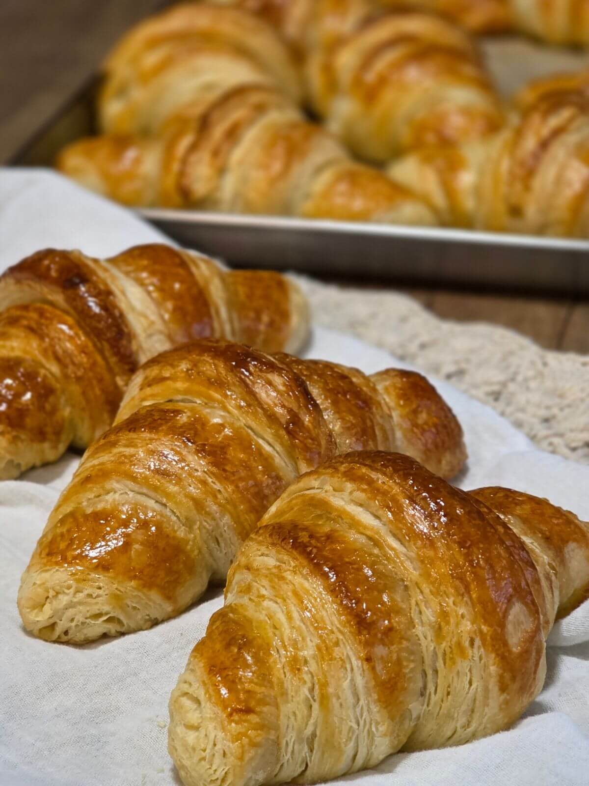 Golden brown sourdough croissants with flaky layers after baking.