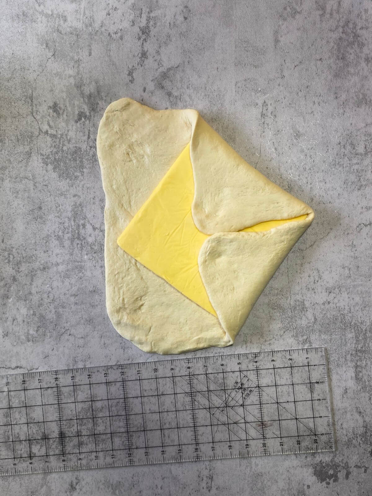 Sourdough croissant dough folded over the butter block like an envelope.