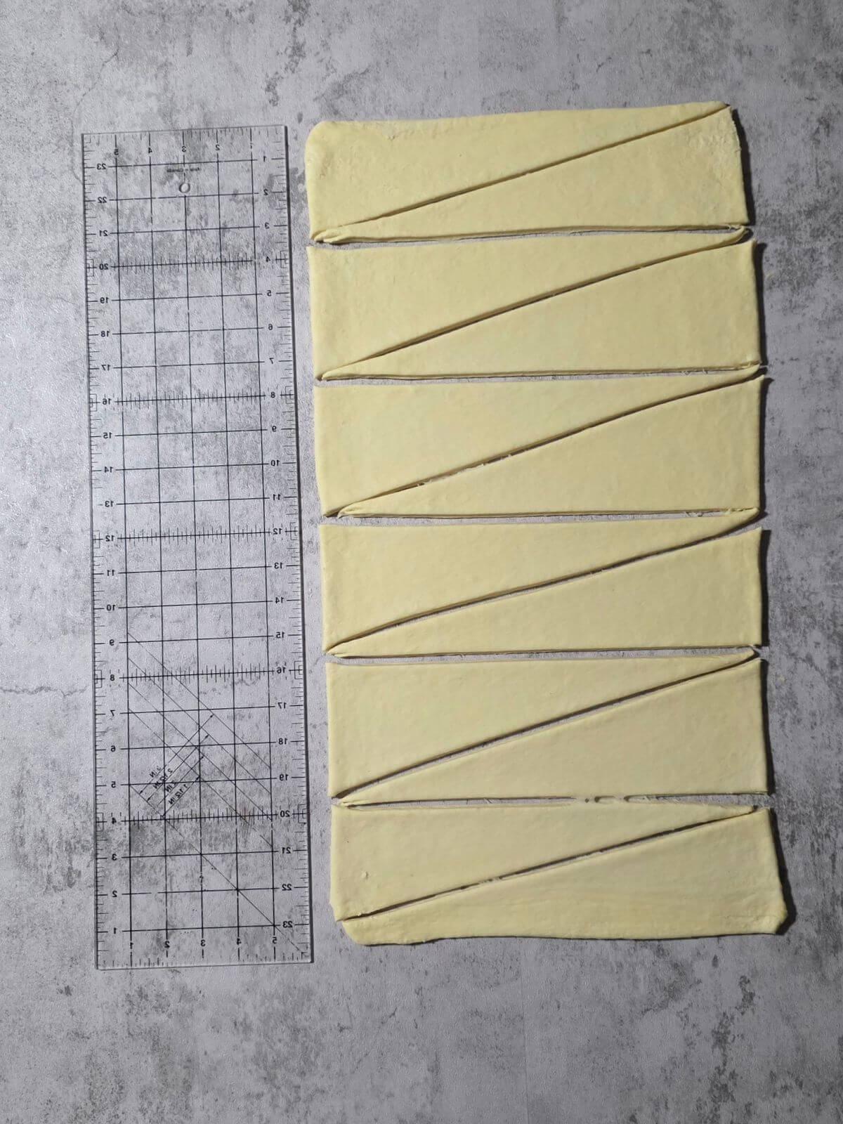 Laminated croissant dough trimmed and cut into long triangles.