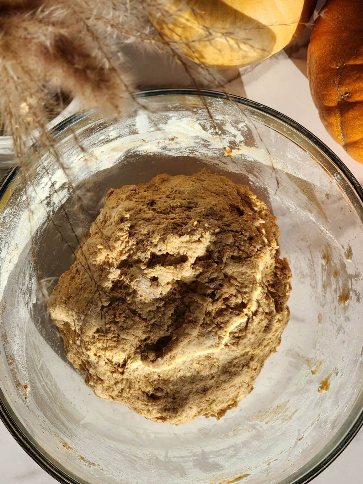 Pumpkin sourdough scone dough mixed together in a large glass bowl.