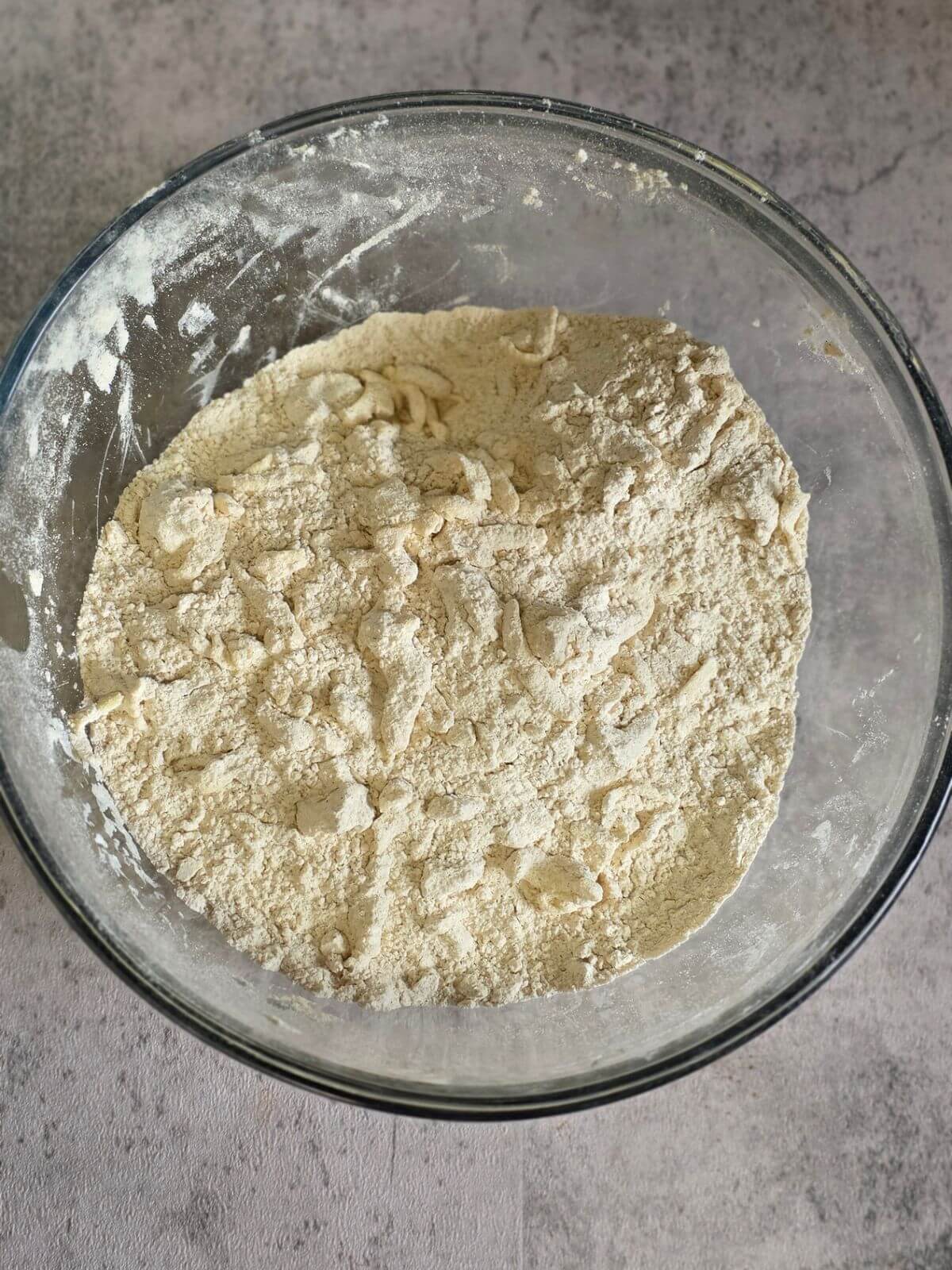 Dry ingredients for pumpkin sourdough scones mixed together in a glass bowl.