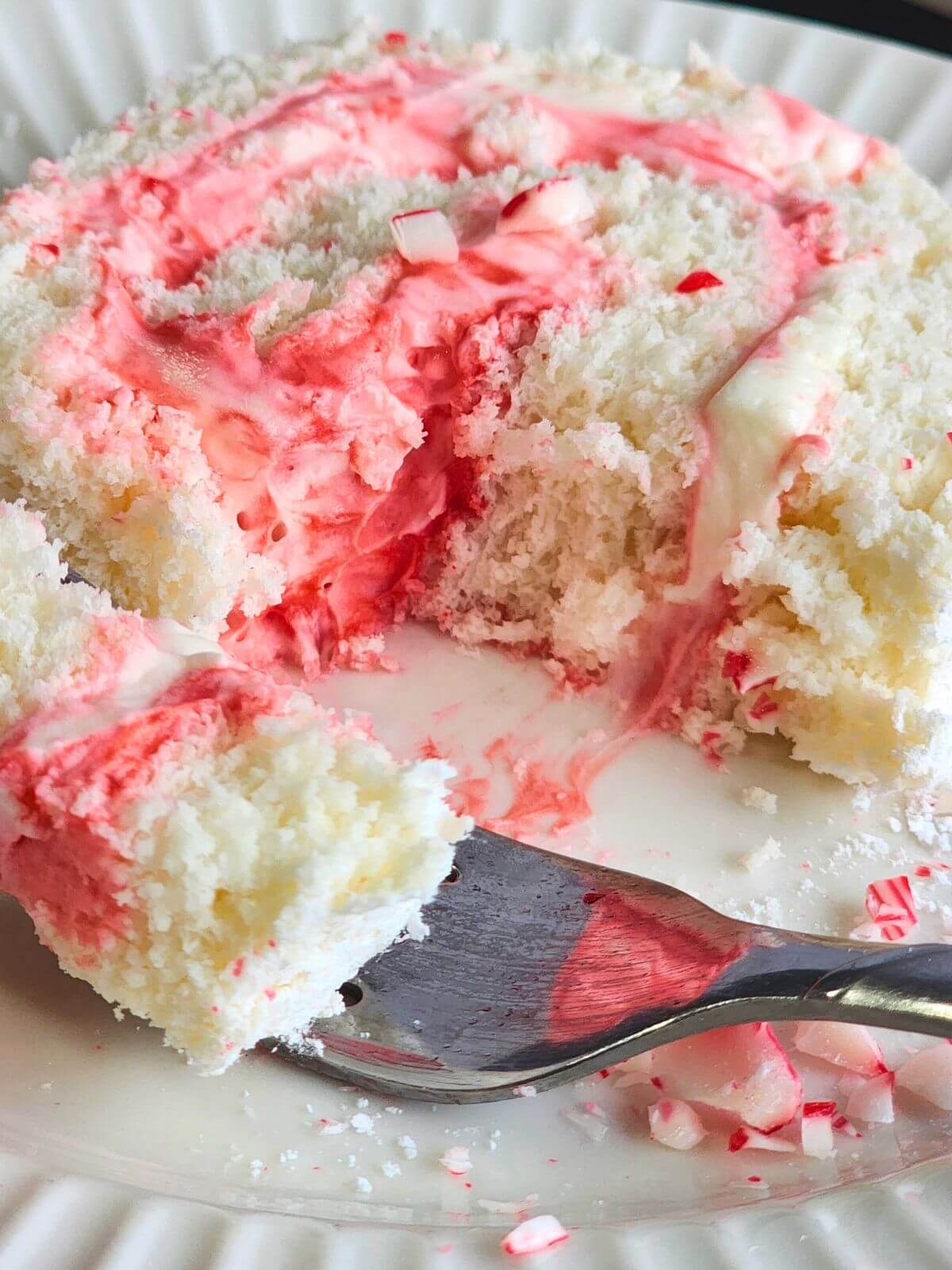 Slice of angel food cake roll with peppermint cream cheese filling and crushed peppermint.