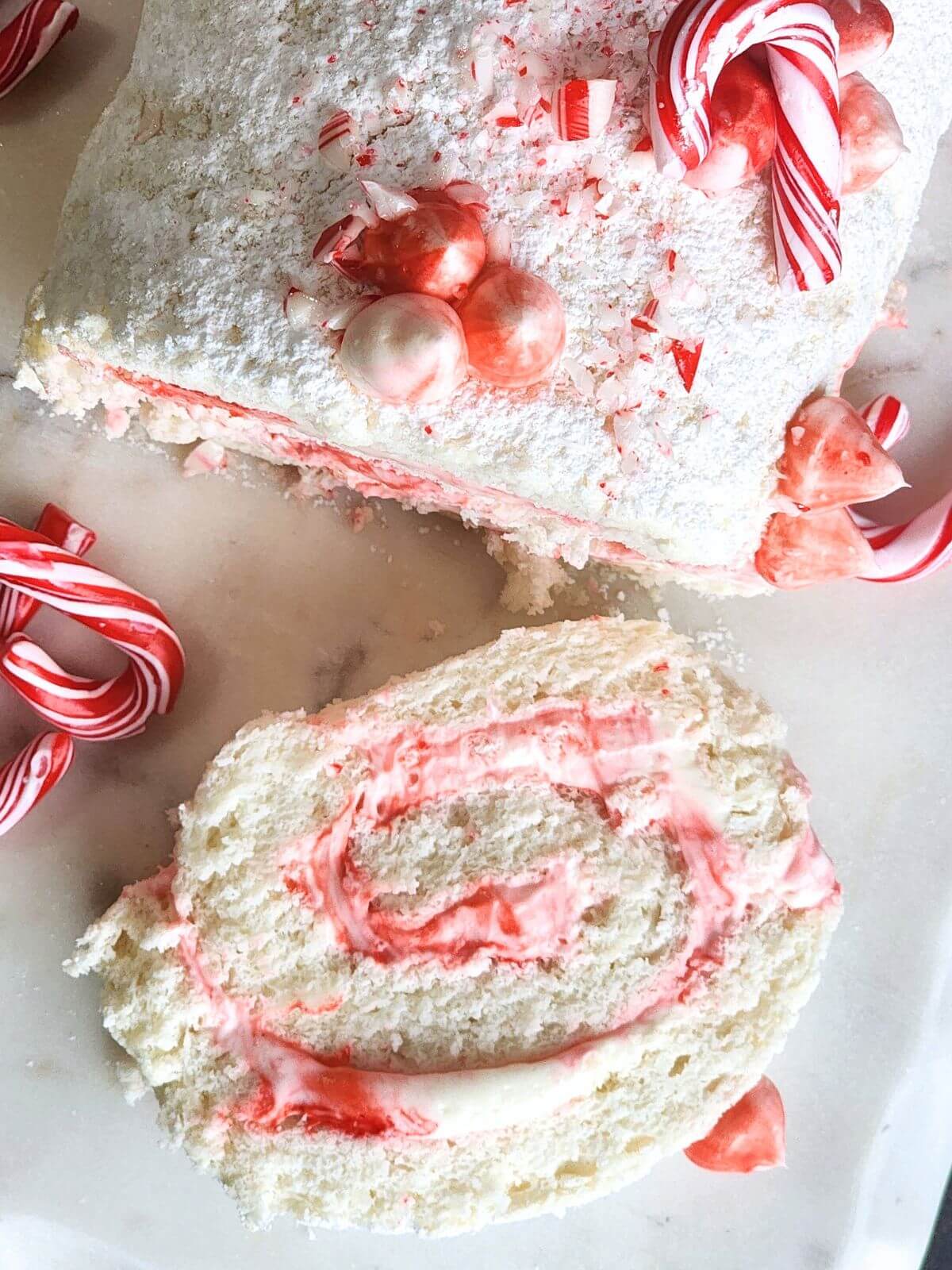 Angel food cake roll with peppermint cream cheese filling and crushed peppermint for a Christmas dessert.