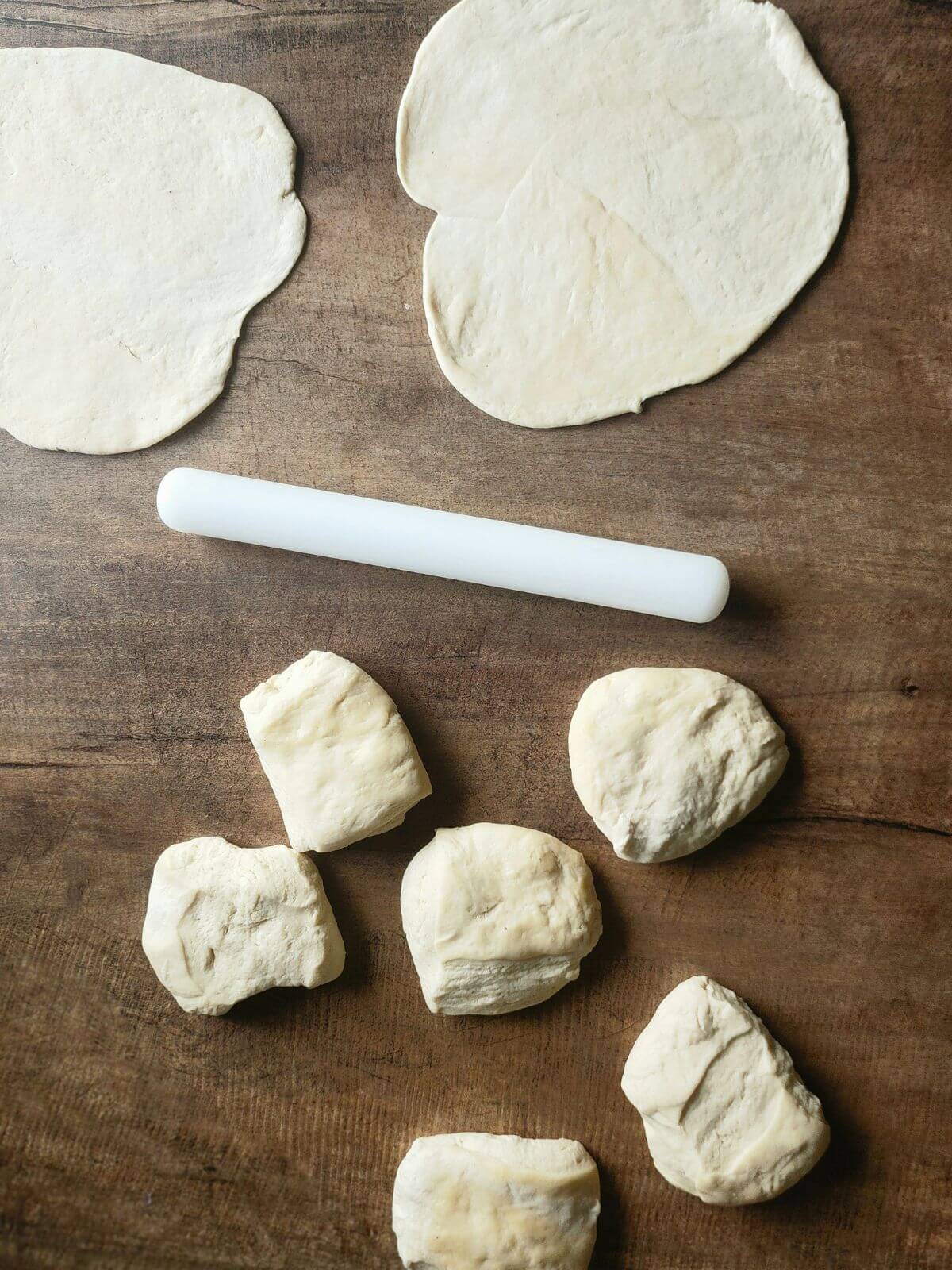Naan dough cut into pieces and2 rolled out.