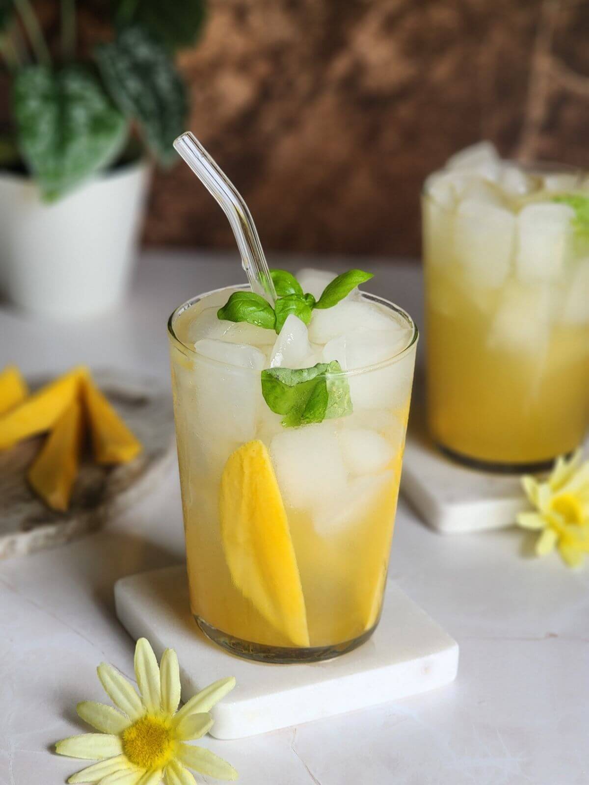 Mango mocktail made with homemade mango syrup, sparkling water, basil, and ice.