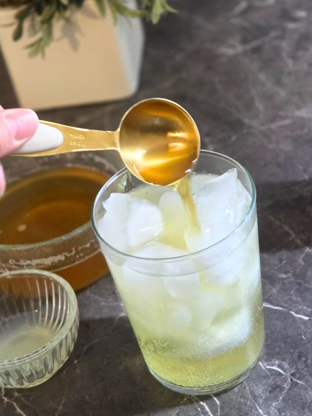 Pouring chamomile syrup into sparkling water.