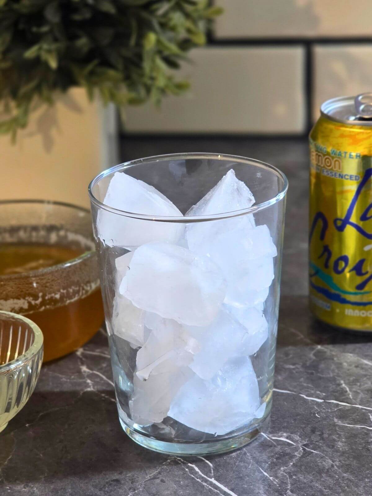 Cup of ice with ingredients for chamomile mocktail.