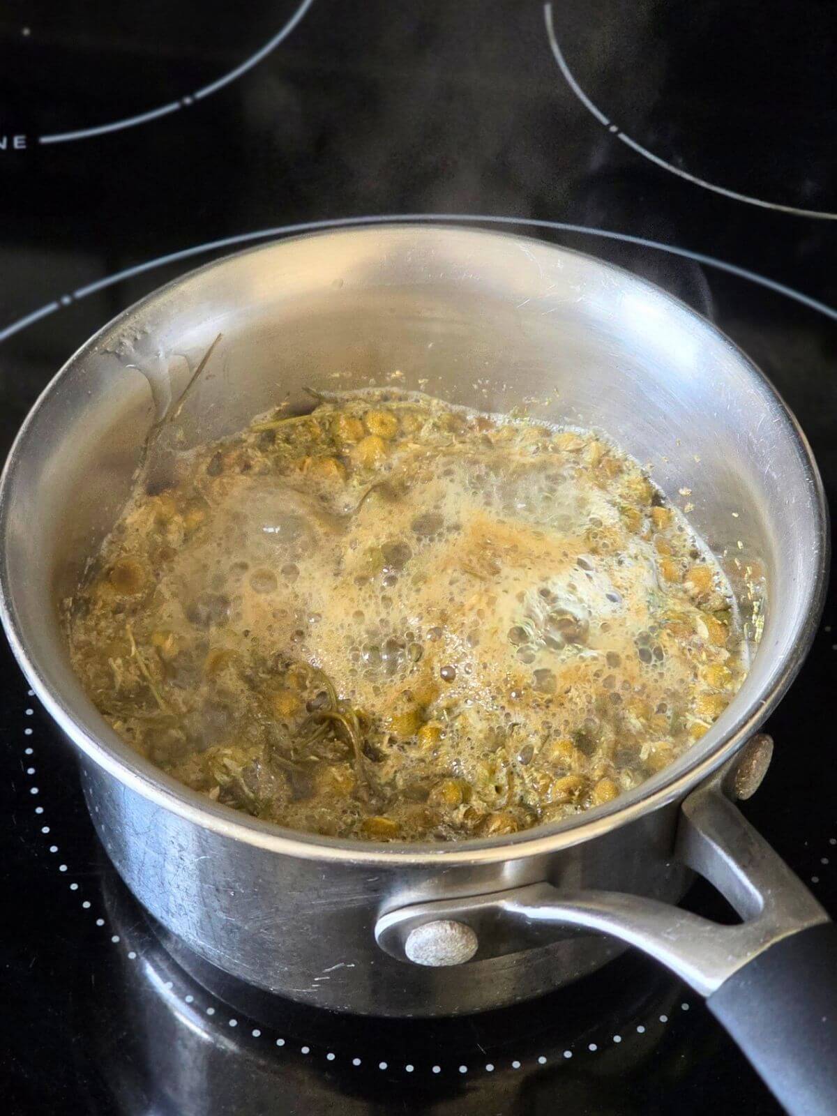 Chamomile cooking in water and honey for syrup.