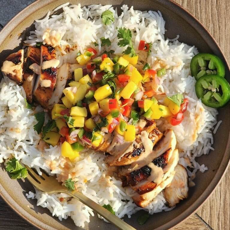 Sweet chili chicken rice bowls with mango salsa, creamy sauce, fresh cilantro, and sliced jalapeños.