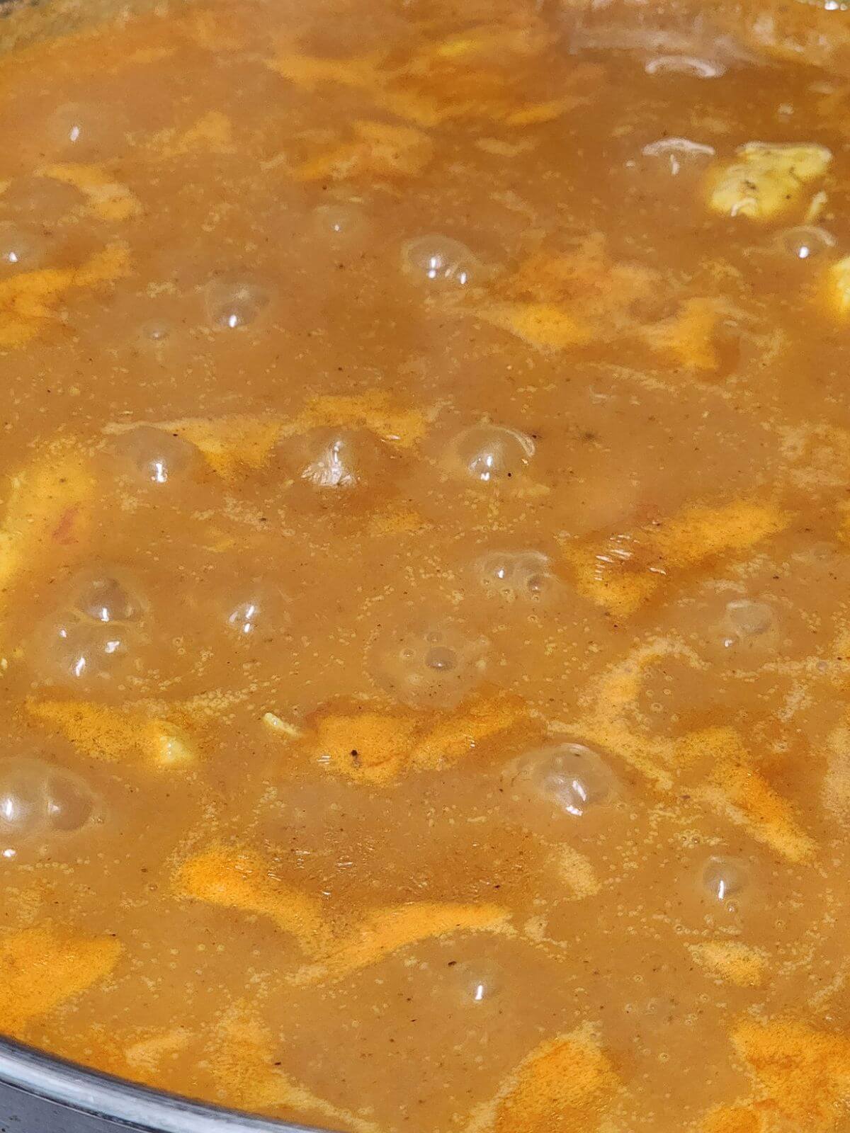 Basmati rice, tomato sauce, coconut milk, and broth stirred into the seasoned chicken.