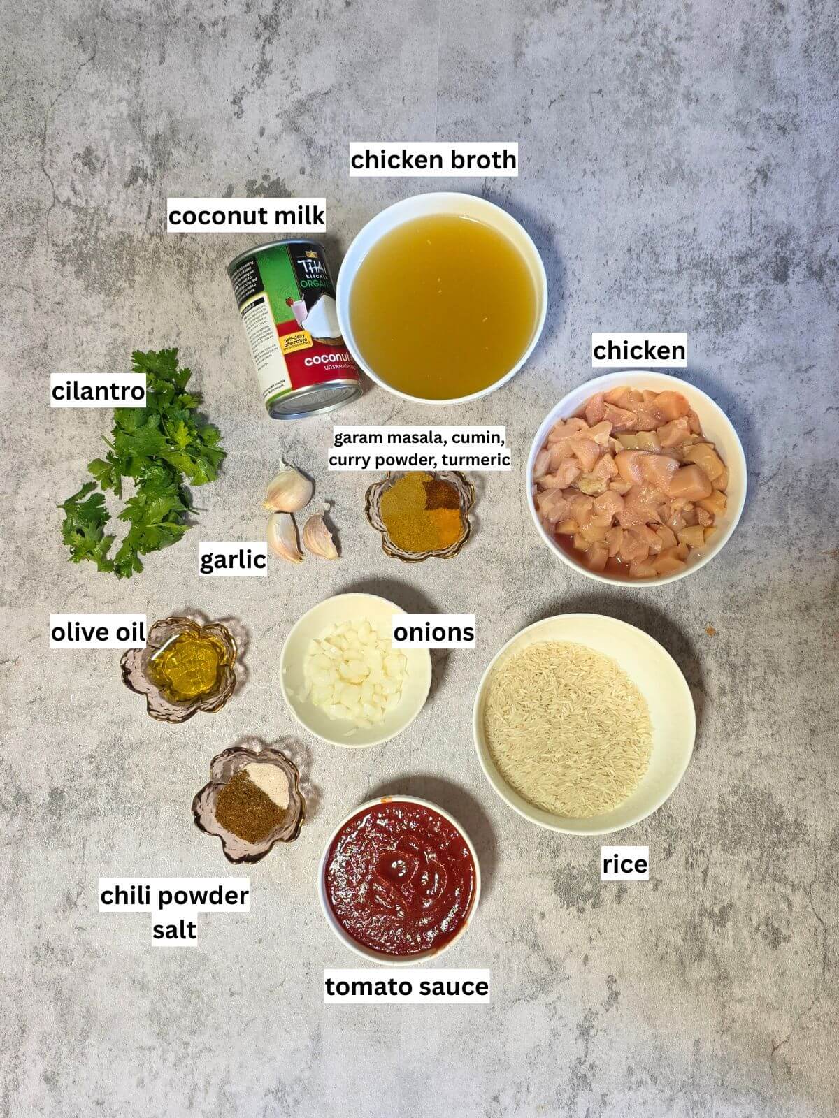 Ingredients for one pot chicken tikka masala rice, including chicken, basmati rice, coconut milk, tomato sauce, onion, garlic, chicken broth, olive oil, cilantro, and spices.