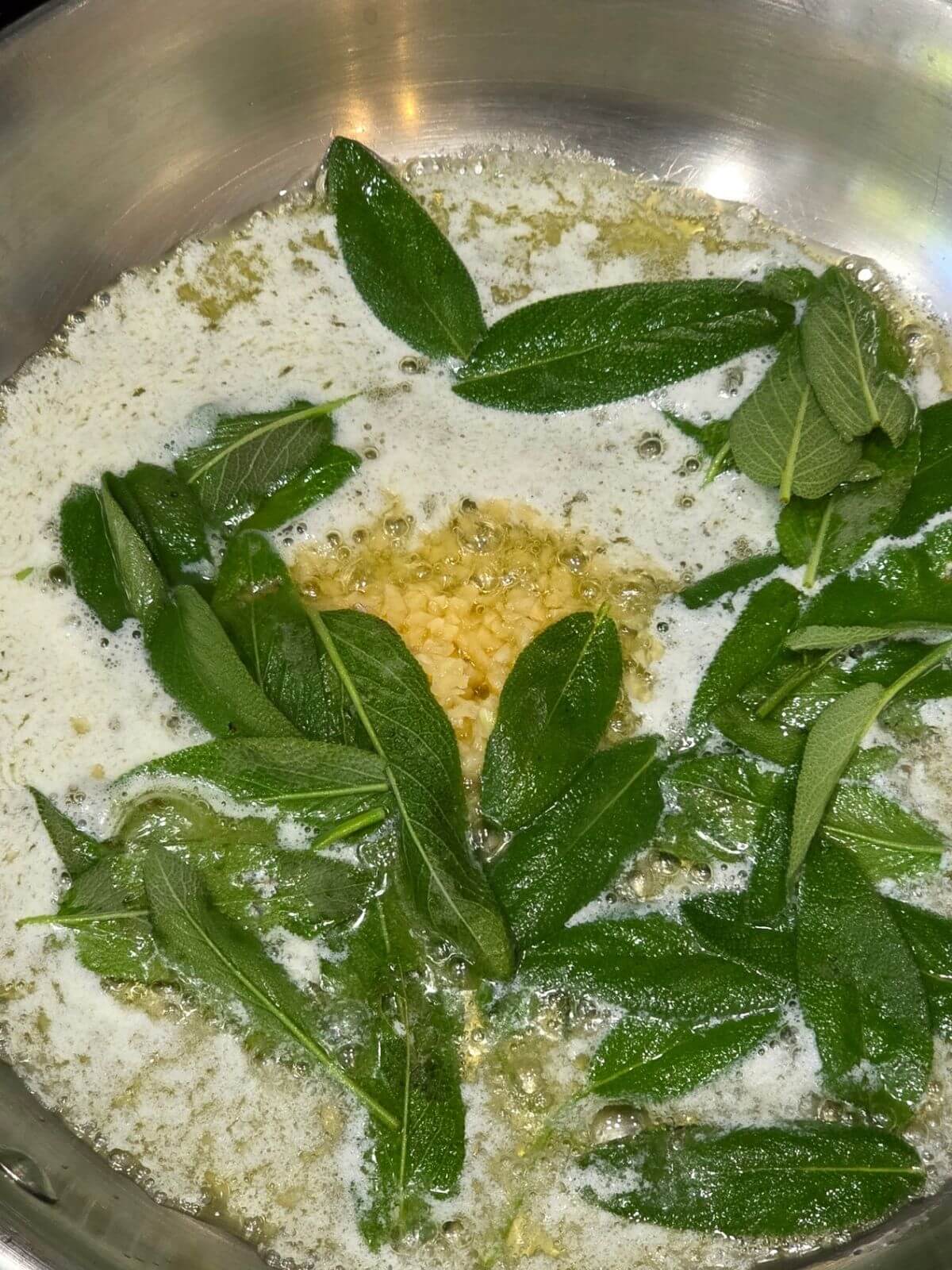 Fresh sage and garlic cooking in melted butter for the sage butter sauce.