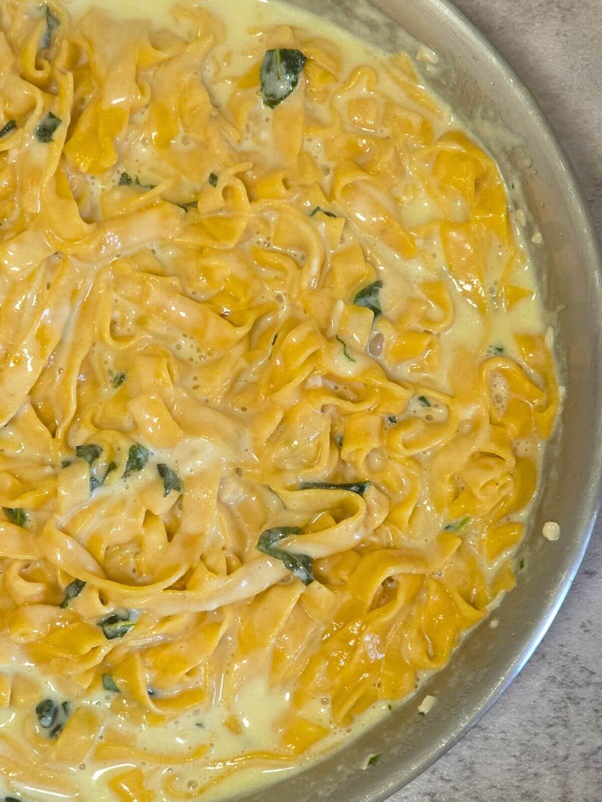 Homemade pumpkin pasta tossed in a creamy sage butter sauce with fresh sage.